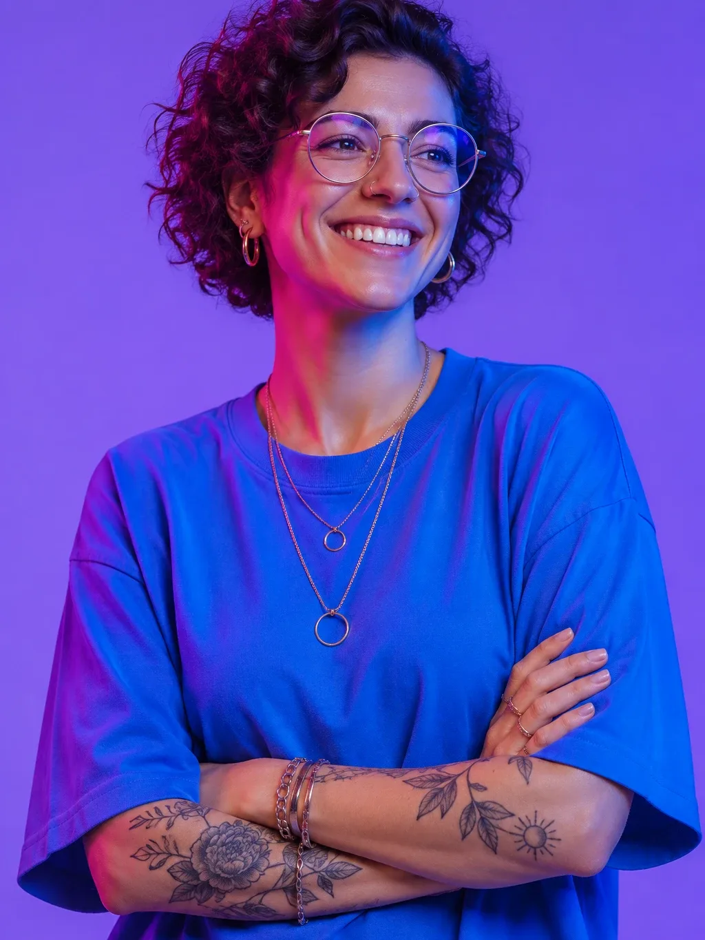 A smiling woman with short curly hair and round glasses