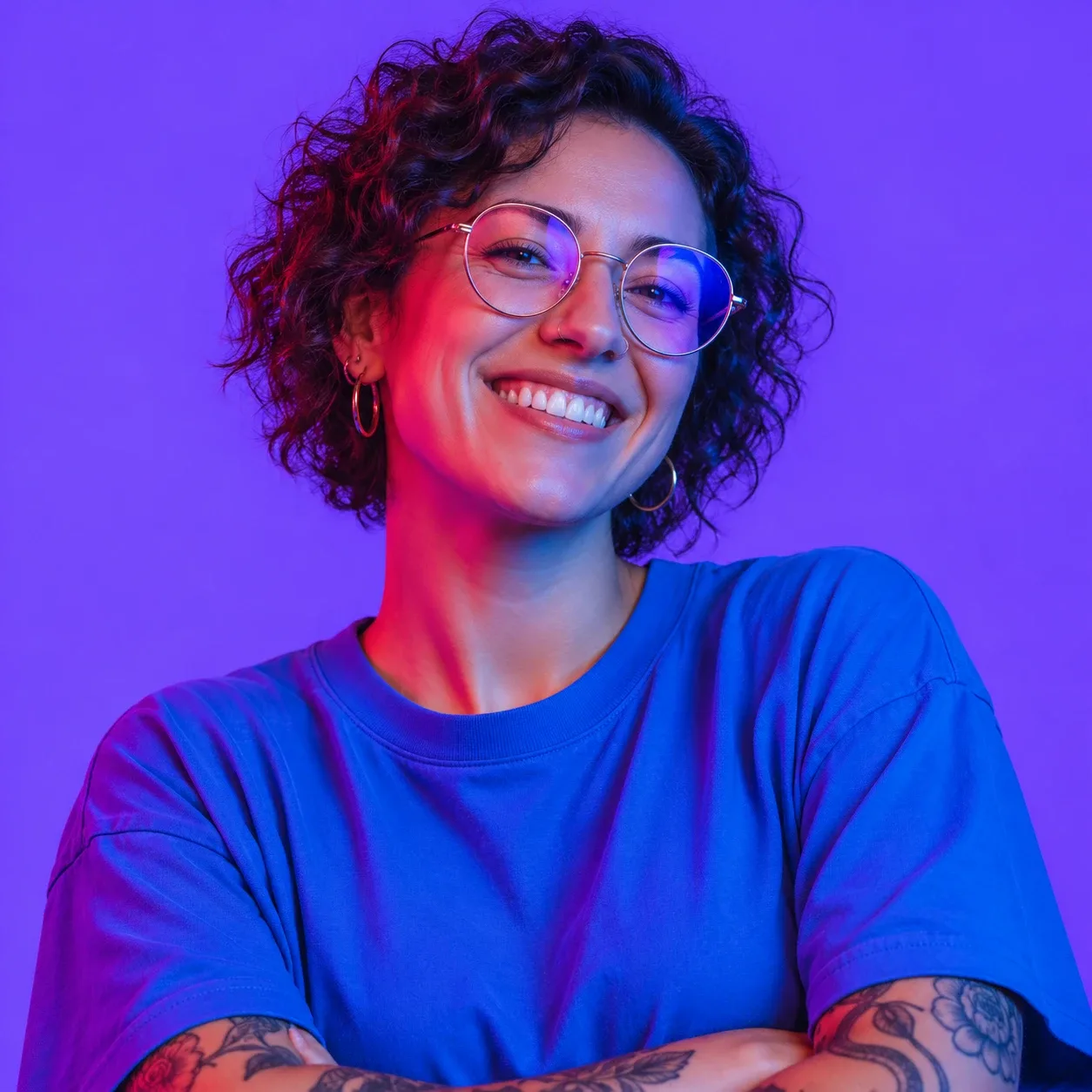 A smiling woman with short curly hair and round glasses