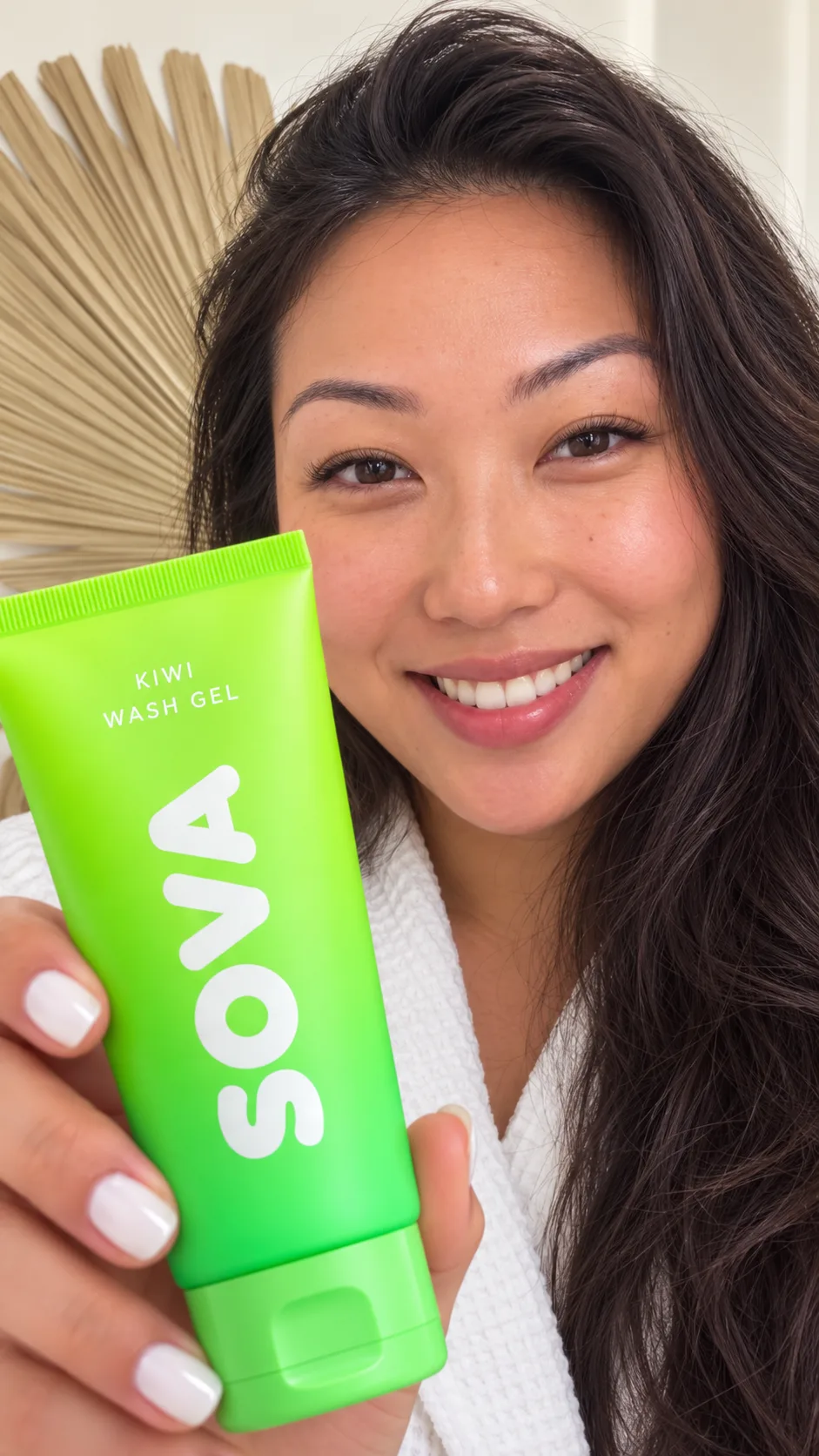 Woman holding a SOVA Kiwi Wash Gel tube close to camera.