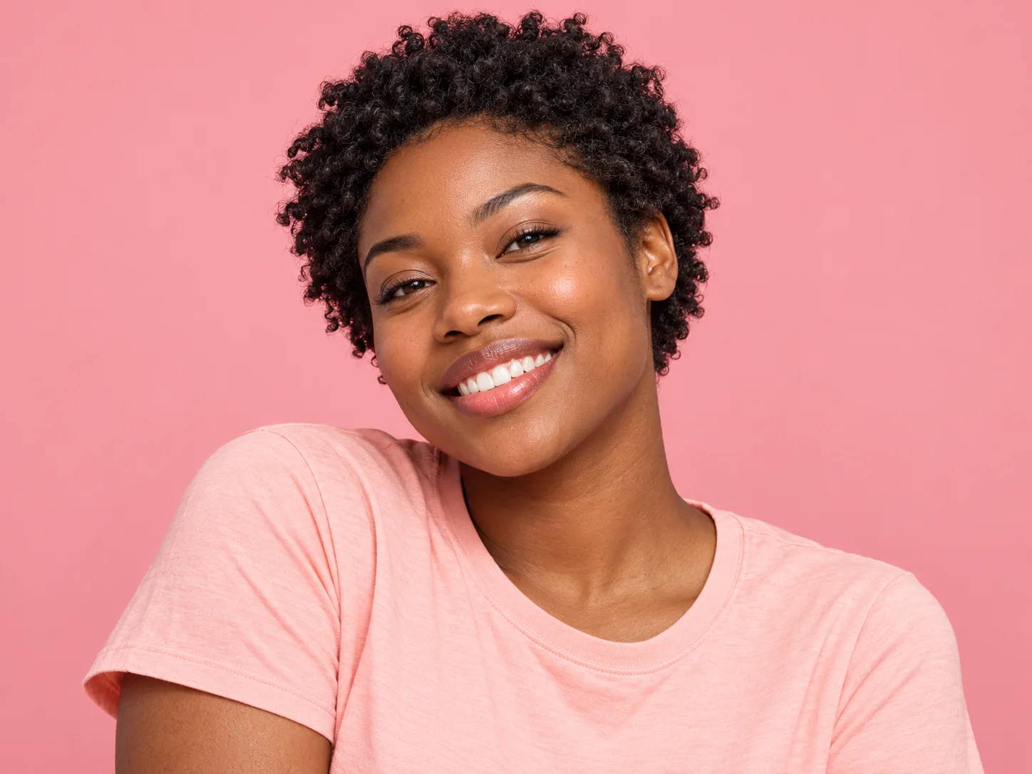 Fictional portrait of Demo reader 3, a woman with short coils and a peach top against a pink background.